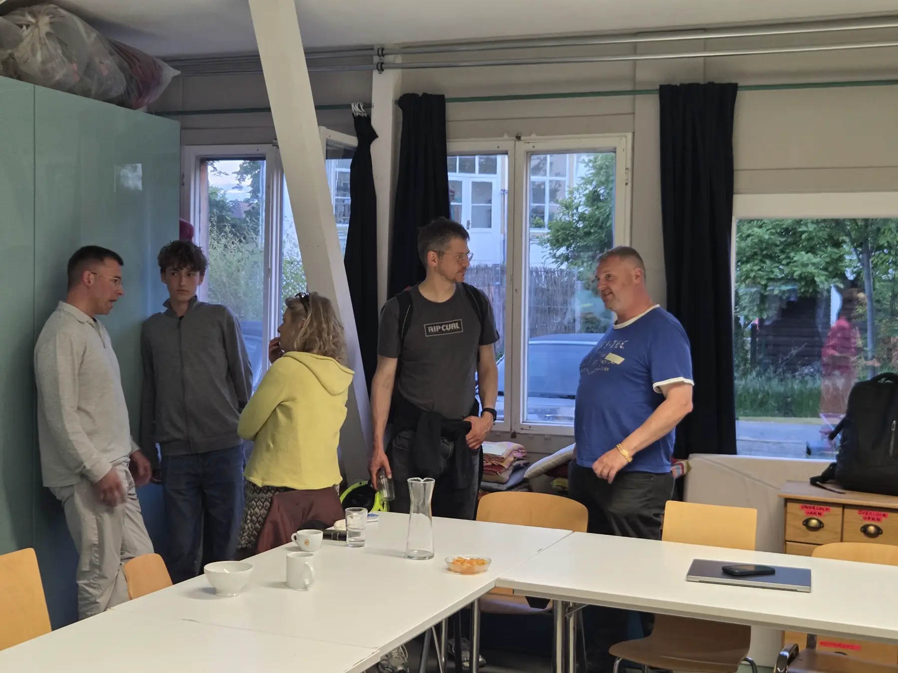Kleine Gesprächsgruppe beim Networking am Fenster.